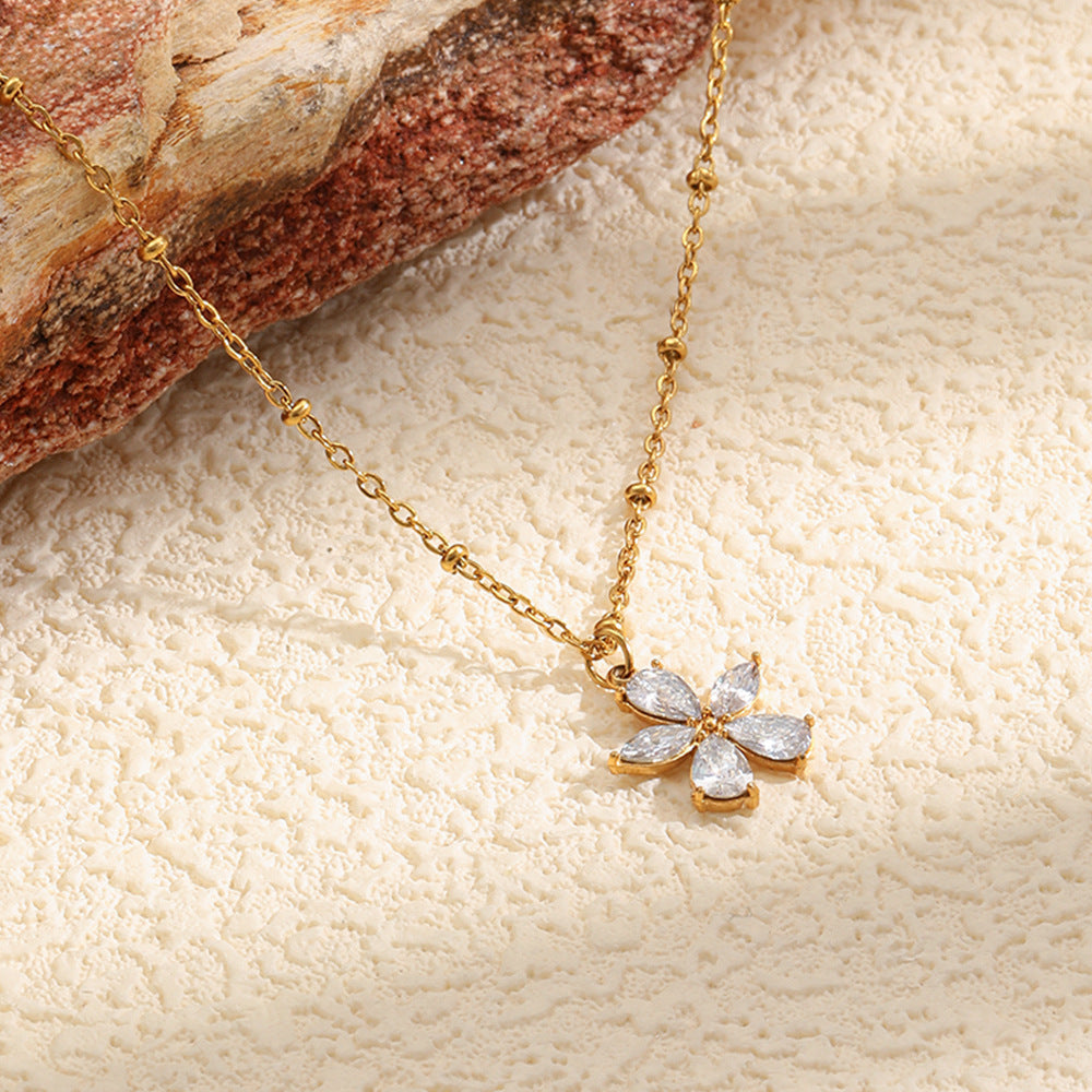 Fine chain with flower pendant beside stone