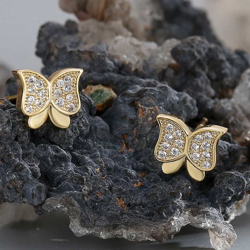 clear zirconia butterfly studs arranged on dark mineral stone