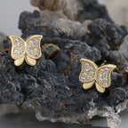 clear zirconia butterfly studs arranged on dark mineral stone