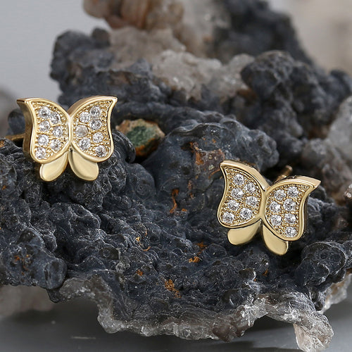 clear zirconia butterfly studs arranged on dark mineral stone