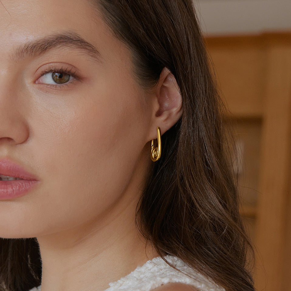 Polished spiral earrings worn with a white top