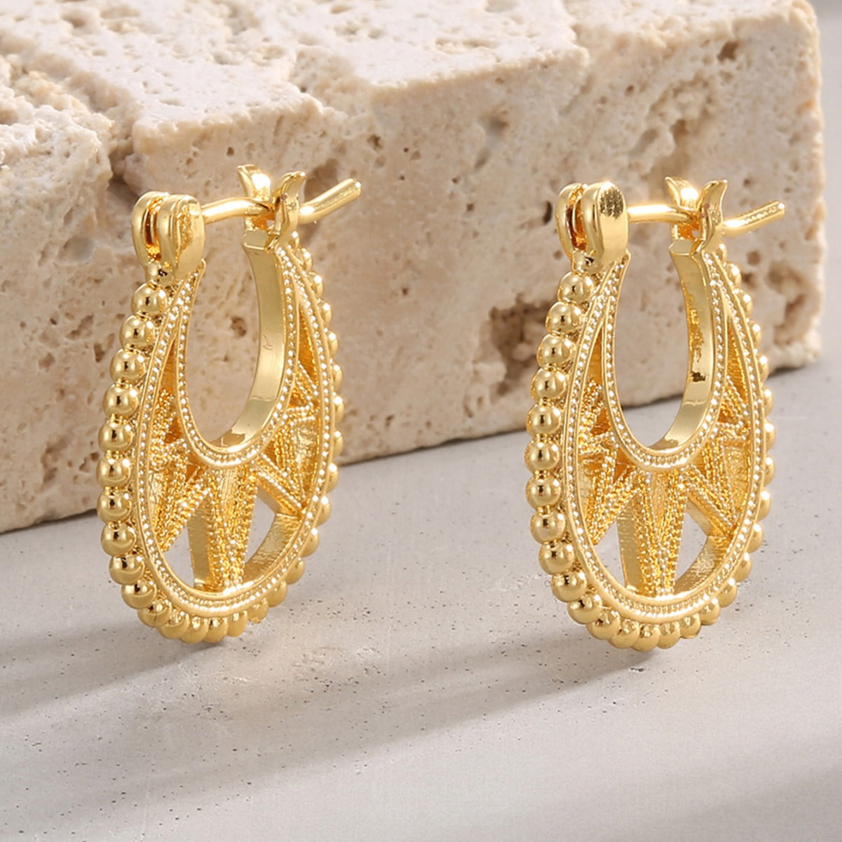 gold plated beaded openwork hoop earrings on stone