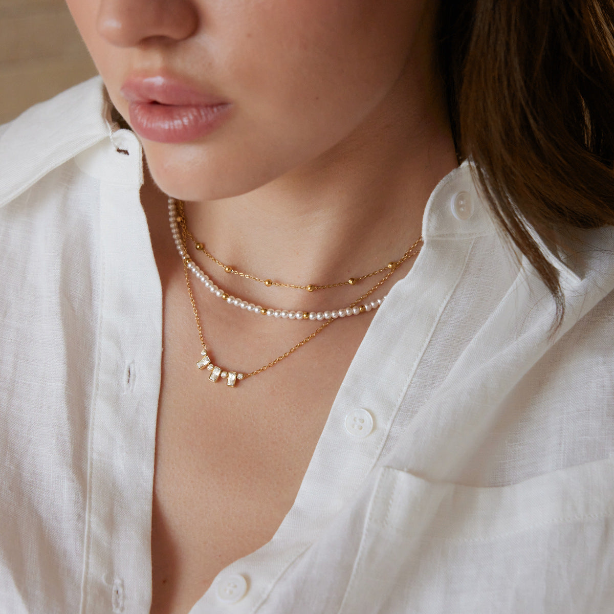 Layered bead necklace worn with the clear-accent chain