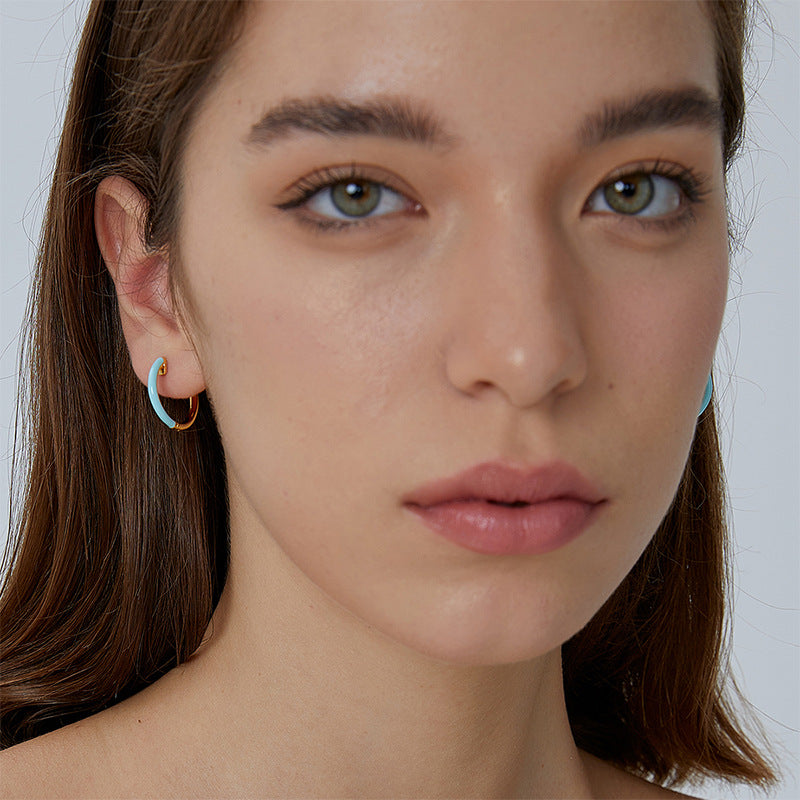 small blue resin accent hoops worn on the ear