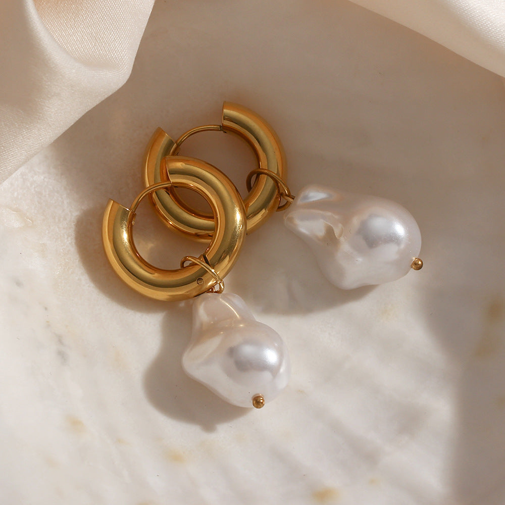 gold plated imitation pearl drop hoop earrings on ivory fabric