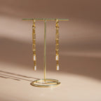 Pair of long chain drop earrings on a display stand
