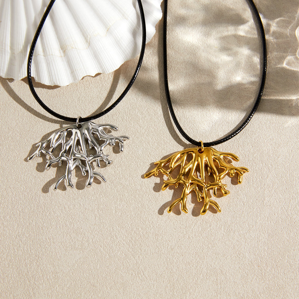Gold and steel color coral pendants beside shells