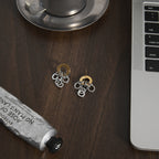 pair of two-tone stainless steel ring-cluster earrings on a desk