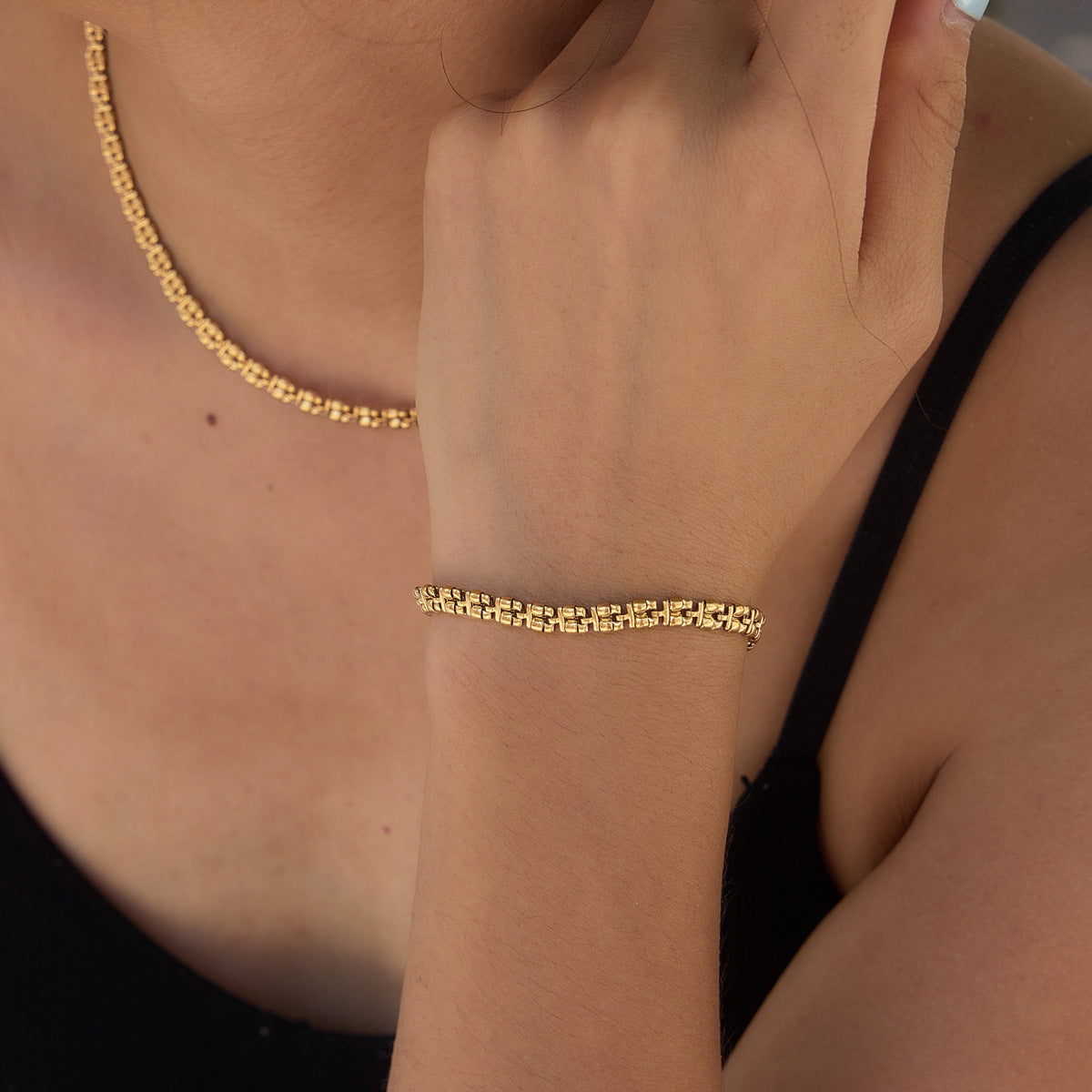 Textured chain bracelet worn with matching necklace