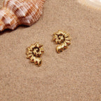 Open-spiral shell studs beside a seashell