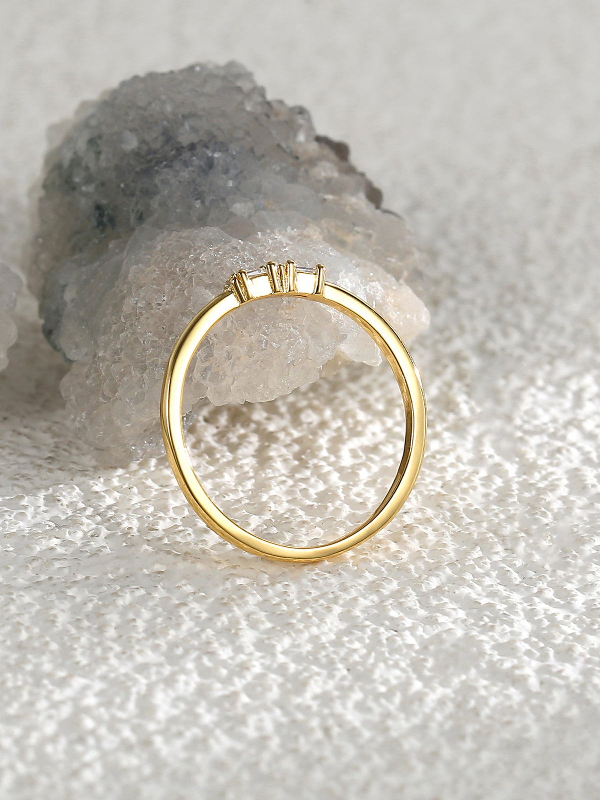 rear view of gold plated band and raised clear-stone settings