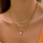 Clear graduated necklace layered with other chains