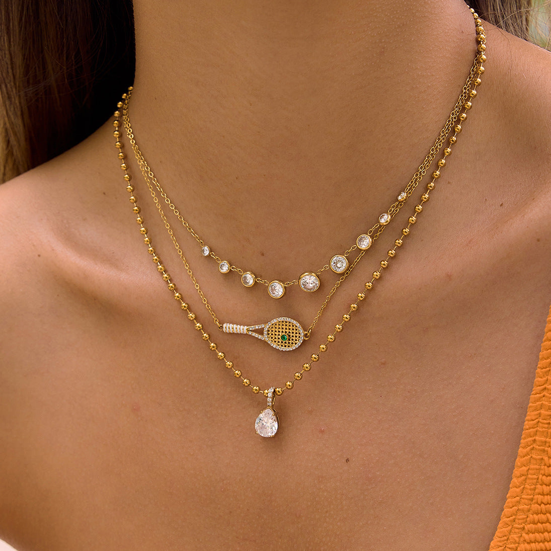 Clear graduated necklace layered with other chains