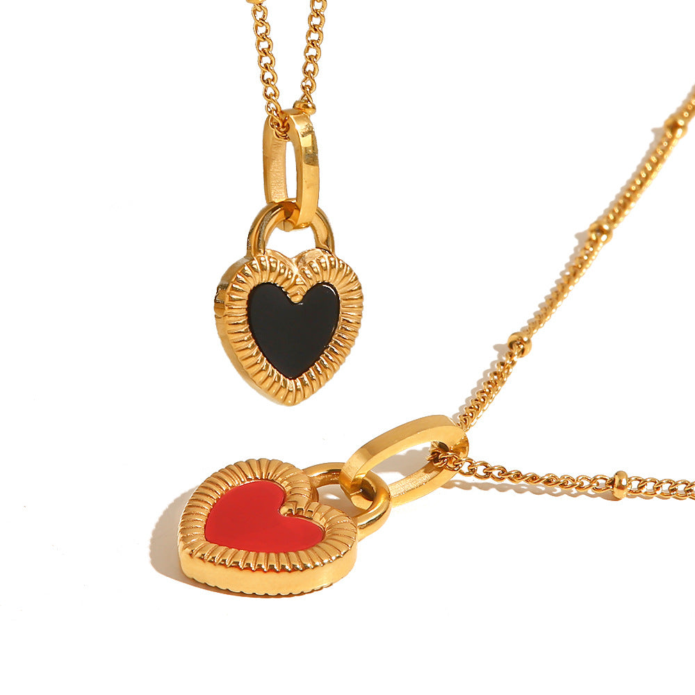 Black heart necklace beside a separate red-heart comparison piece