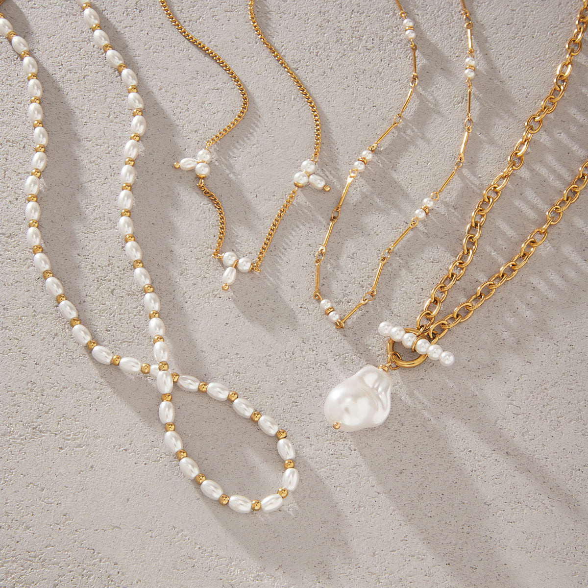 Four necklaces with pendant and spaced bead designs laid flat
