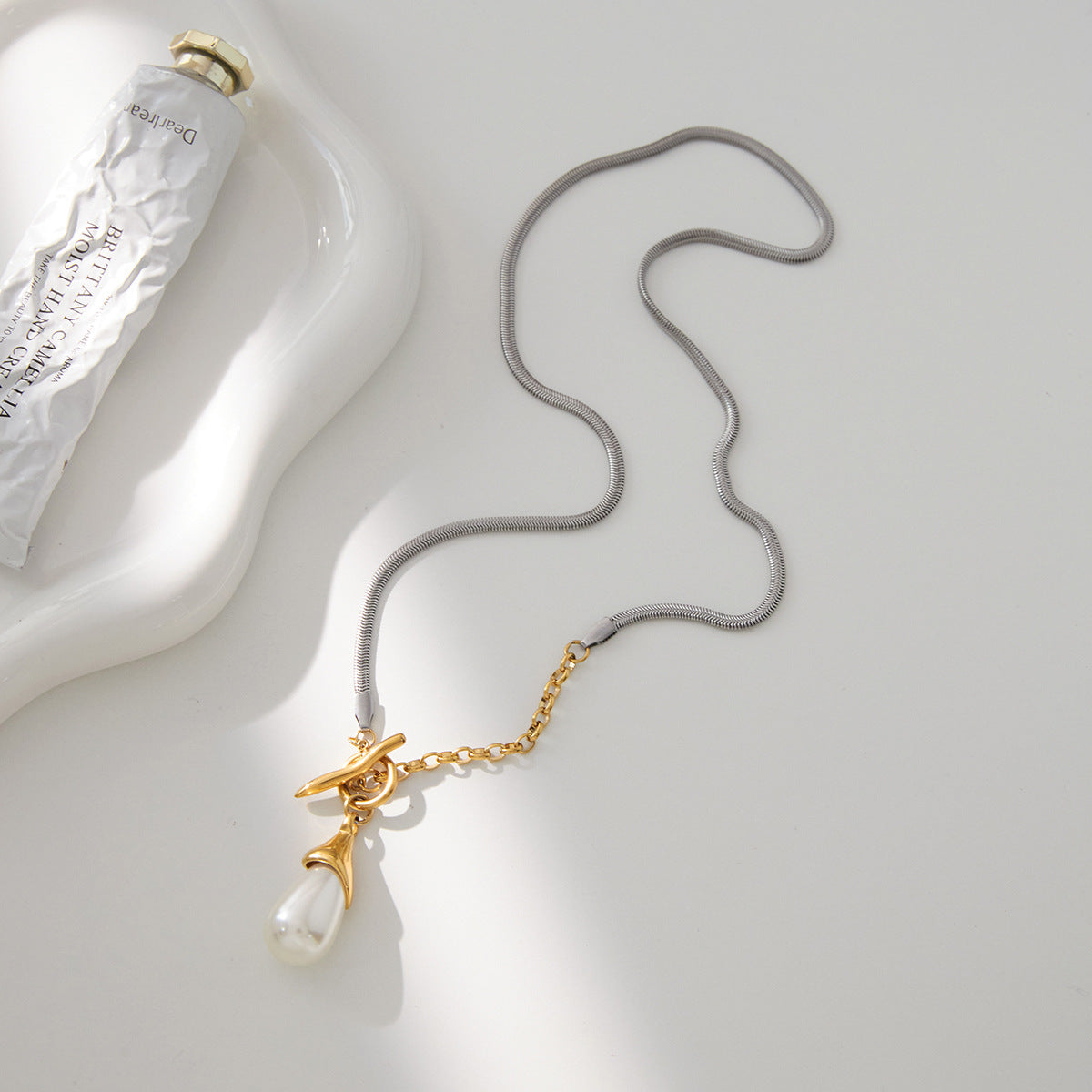 Full mixed-chain toggle necklace arranged on a pale surface