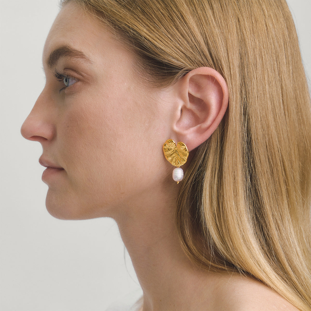 gold plated embossed leaf and freshwater pearl earrings worn on model