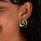 Green oval accent spiral stud earring worn close-up