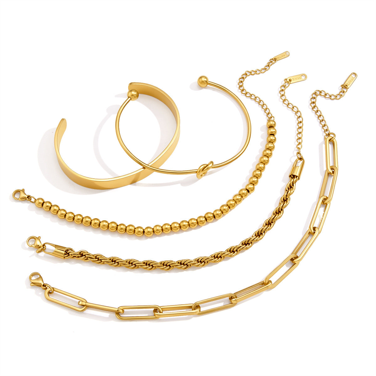 Chain bracelets and open cuffs on white