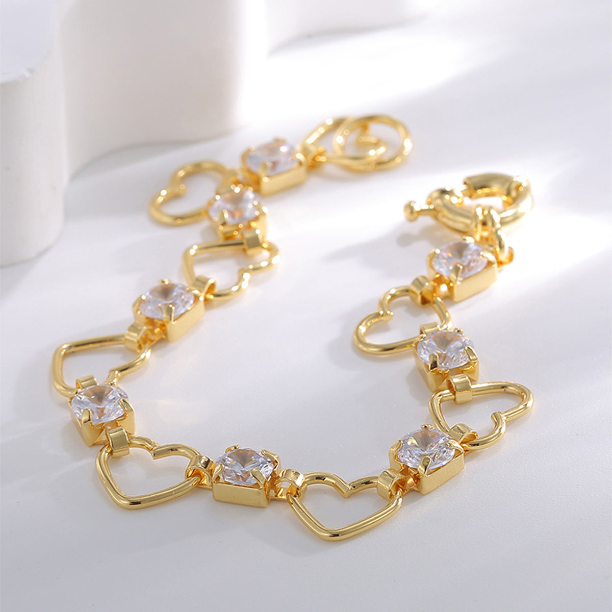 gold plated heart link bracelet arranged in a soft curve