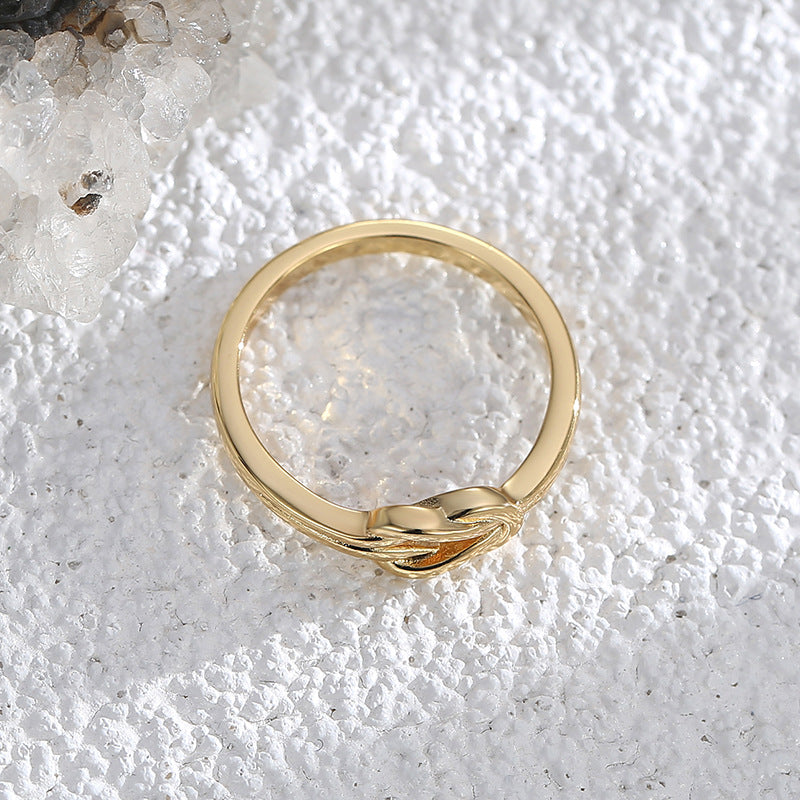 overhead view of slim gold plated band and interlaced knot