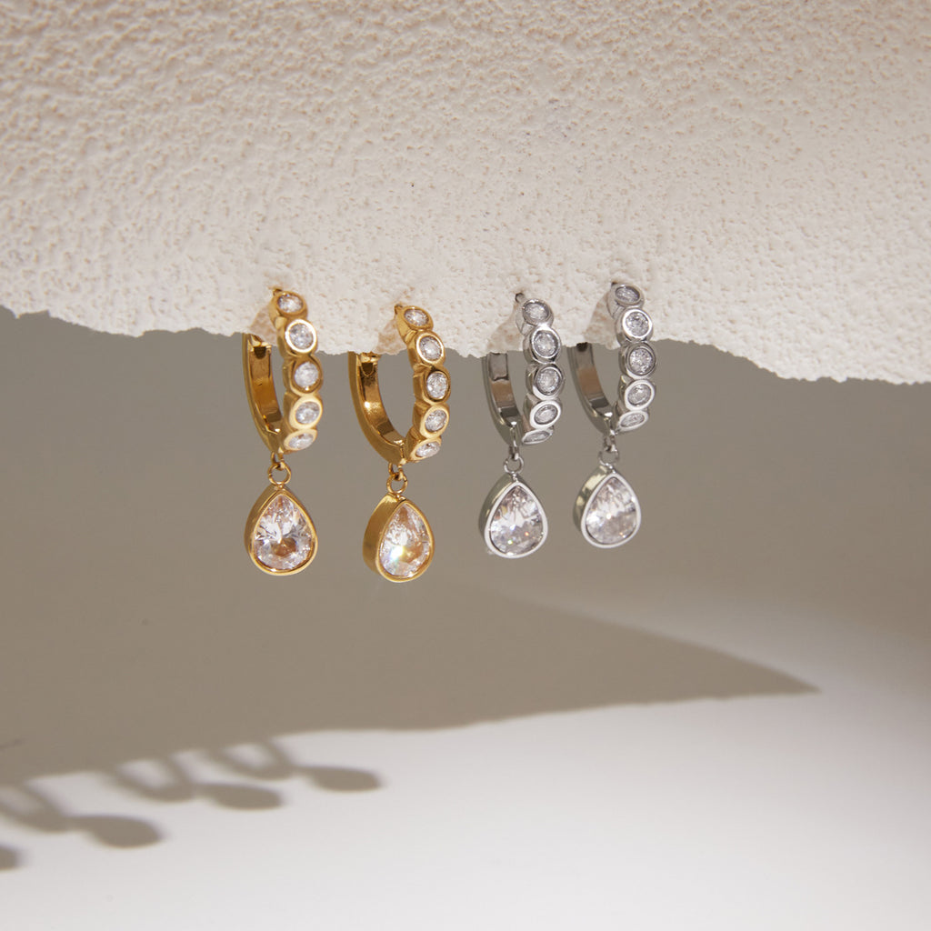 Gold and silver tone clear stone huggies hanging in pairs
