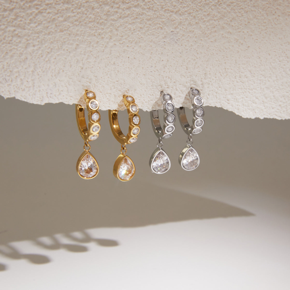 Gold and silver tone clear stone huggies hanging in pairs