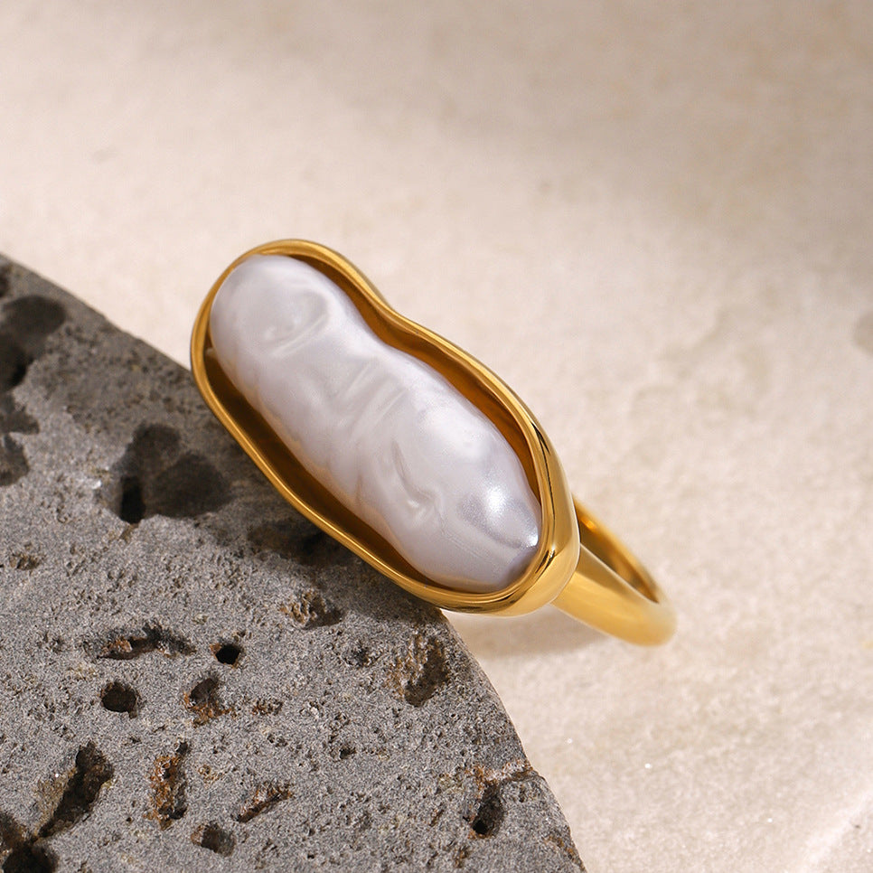 Gold plated elongated white inlay ring on a stone prop