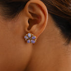 gold plated pearlescent flower stud earrings worn on ear