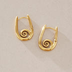 Pair of spiral hoop earrings on stone