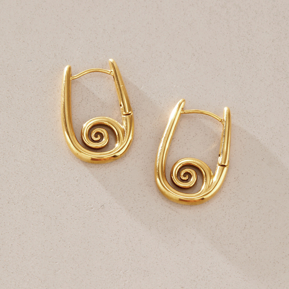 Pair of spiral hoop earrings on stone