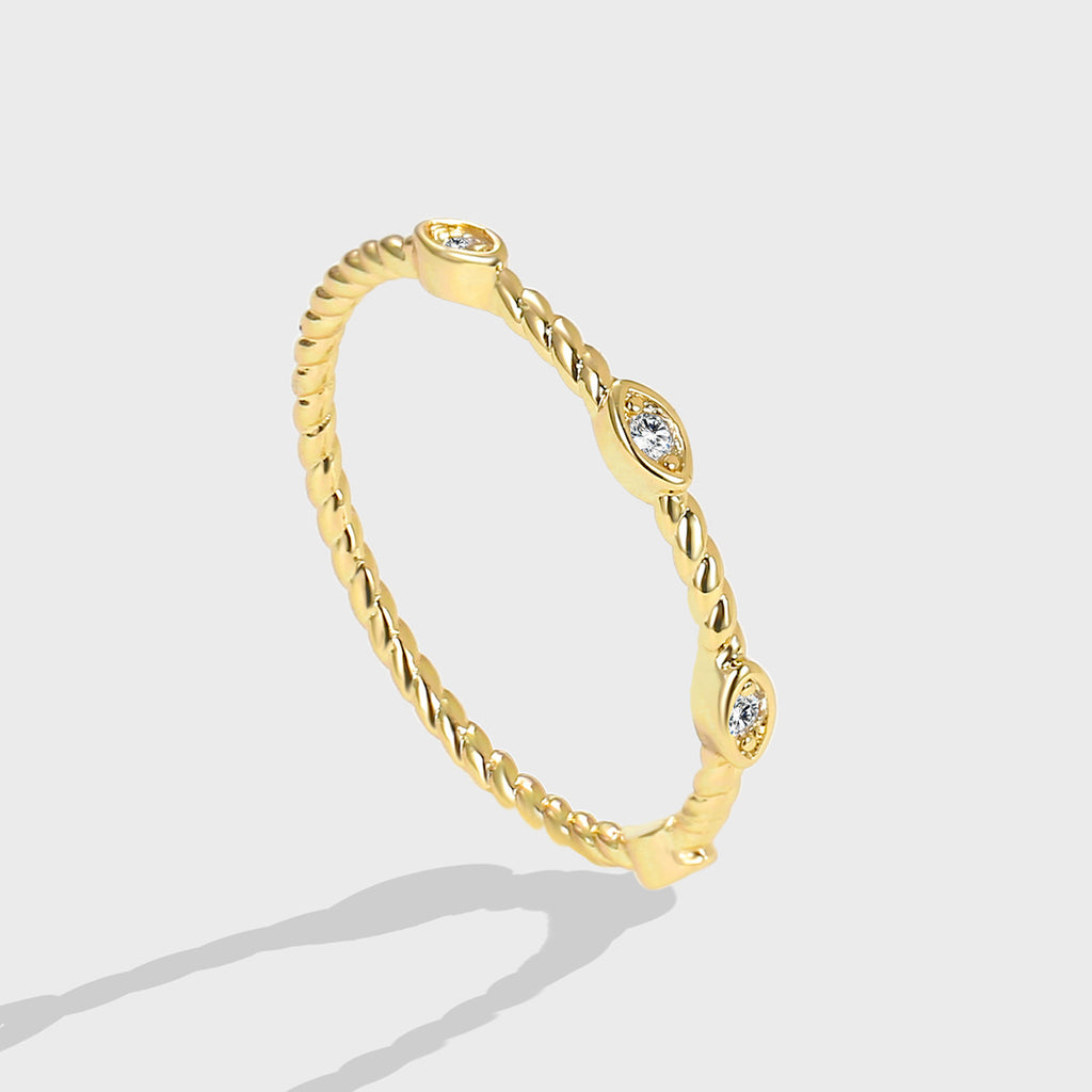 isolated gold plated twisted stacking ring with three clear stones
