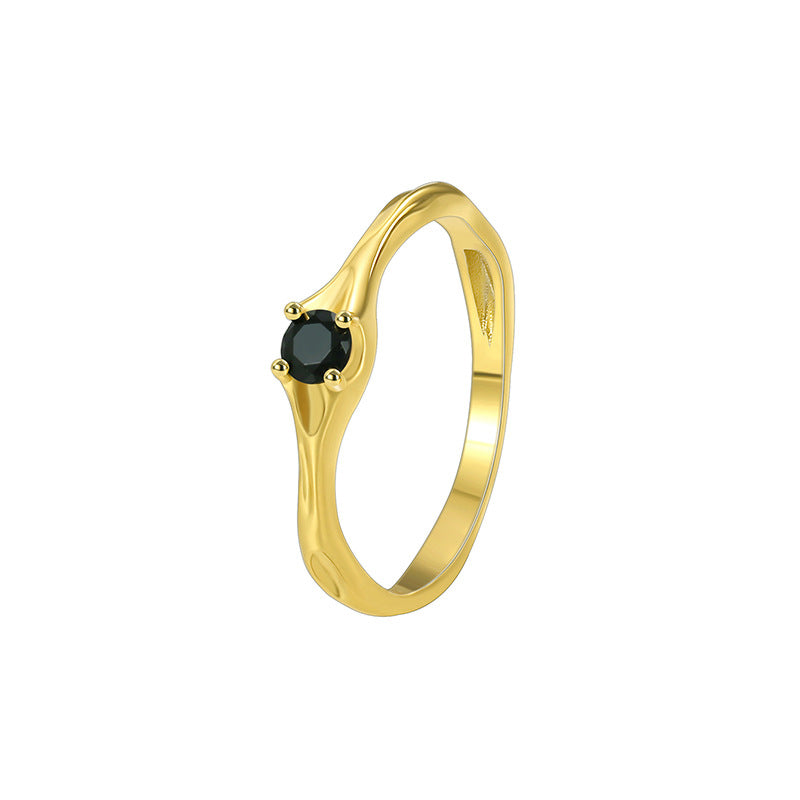 isolated gold plated brass ring with compact black center stone