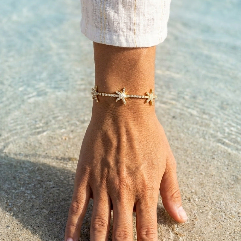Wearing view of three starfish motifs along the stone-set bracelet