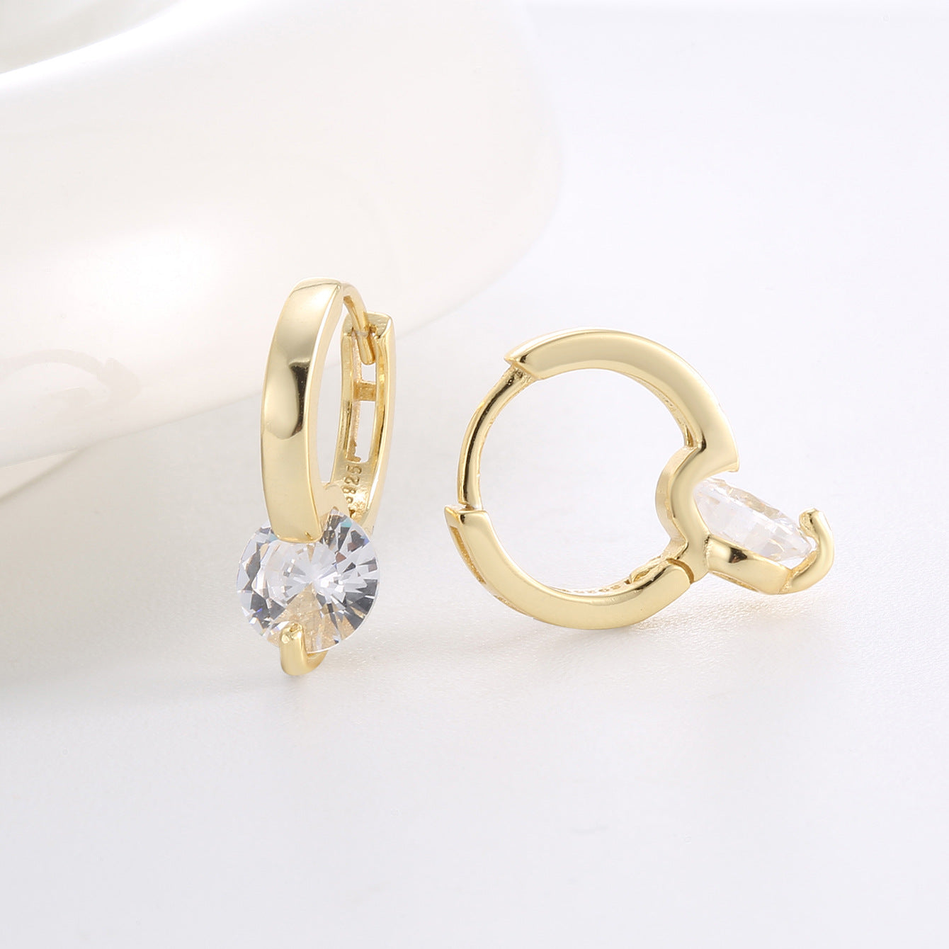 open hinged hoop and side setting of clear round zirconia earrings