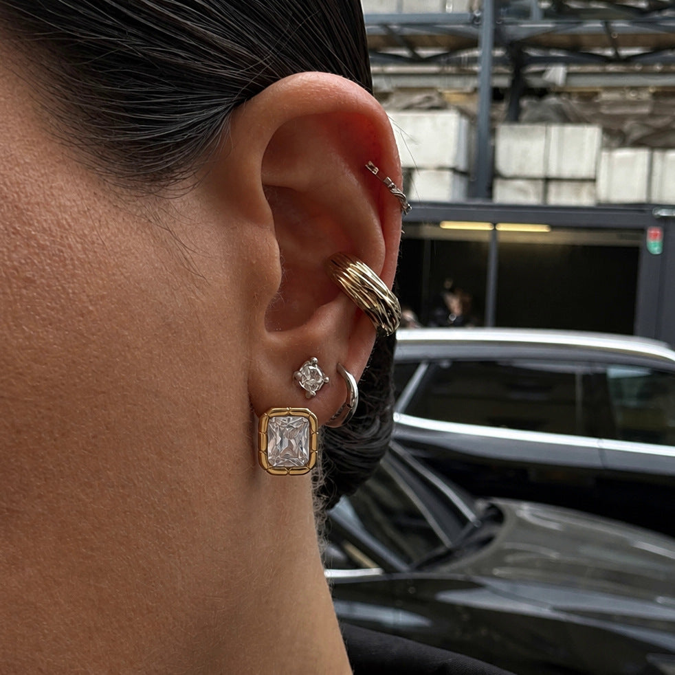 Rectangular stud worn alongside other ear jewelry