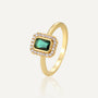 isolated gold plated brass halo ring with emerald-cut green zirconia