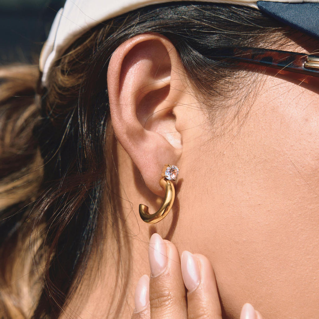 model wearing gold plated clear stone C-hoop earrings