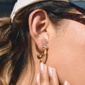 model wearing gold plated clear stone C-hoop earrings