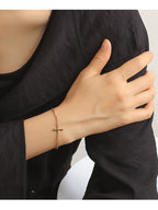 gold plated cross-shaped bar bracelet shown on the wrist