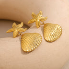 textured stainless steel shell drop earrings on fabric