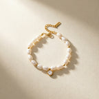 Gold plated bracelet with pearl-look beads on a neutral surface