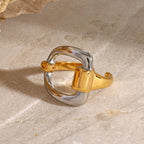 Rounded-square two-tone ring displayed on stone