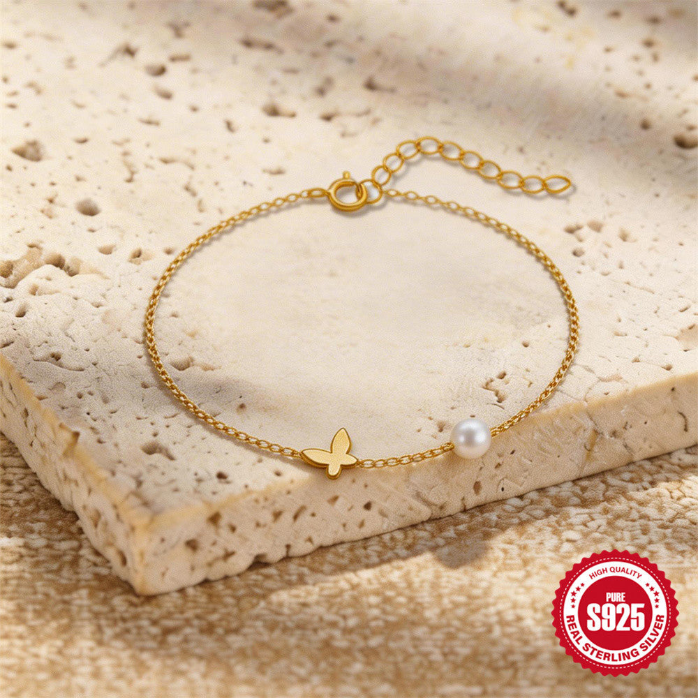 butterfly anklet with pearl-style bead styled on a stone display