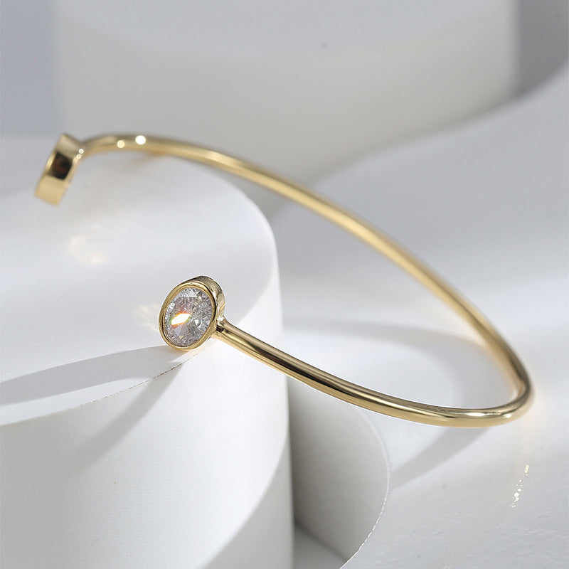 angled close-up of gold plated oval stone cuff bracelet