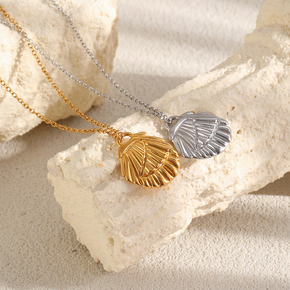 Two shell pendants showing raised ridges and curved surface lines