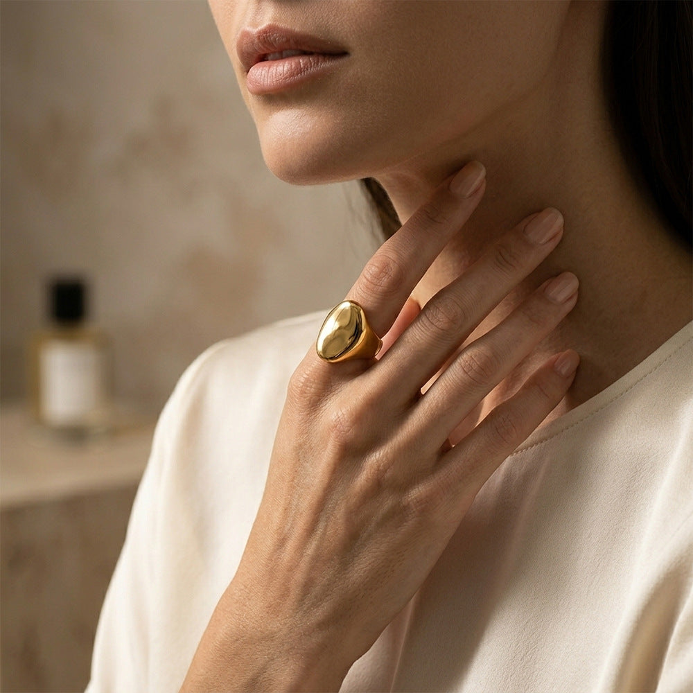 Gold-tone sculptural ring worn on a finger