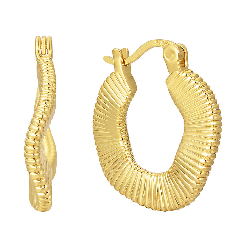 gold plated irregular ribbed hoop earrings isolated on white