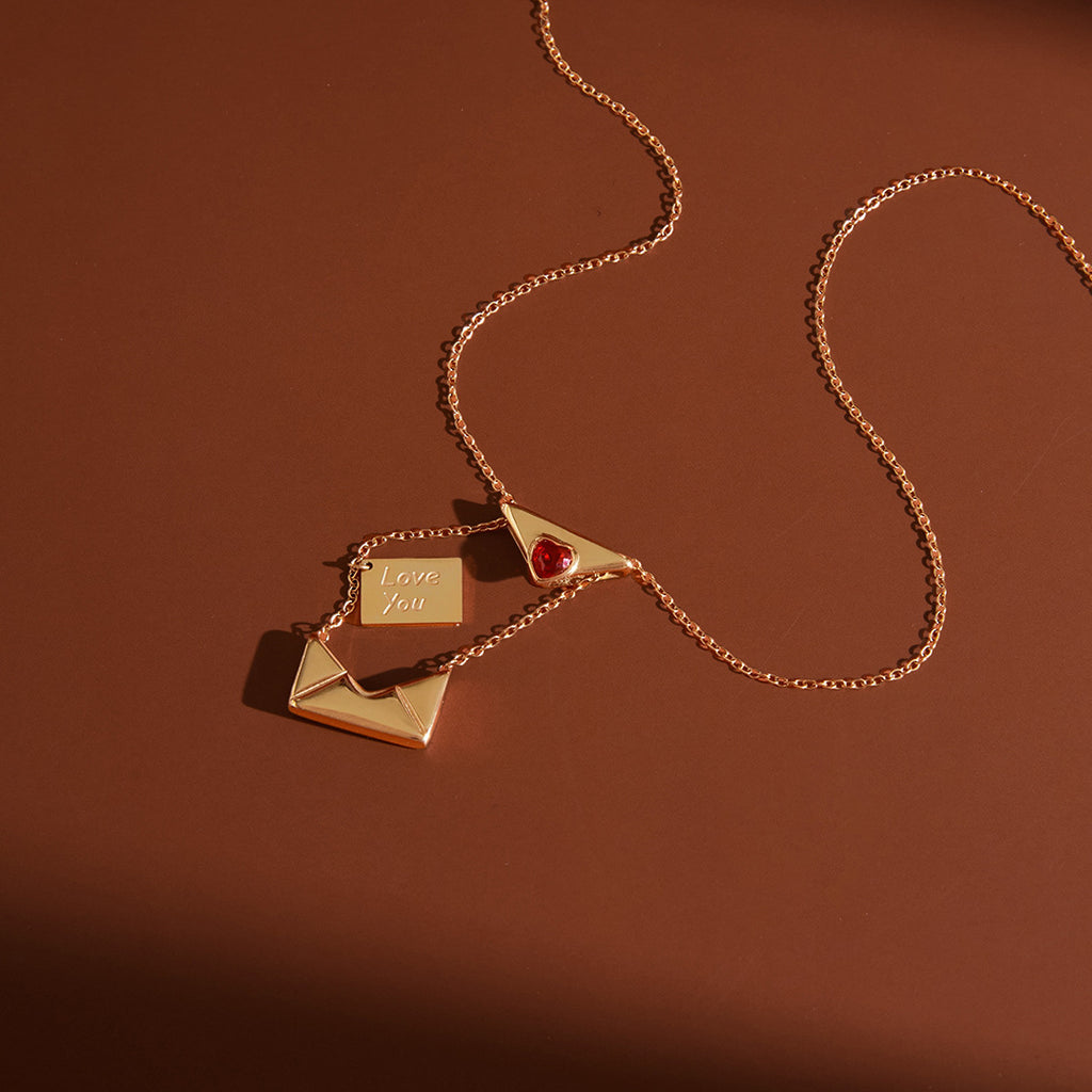 styled gold plated envelope necklace opened to show Love You letter