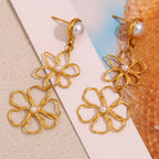 gold plated open-line flower drop earrings styled on a neutral surface